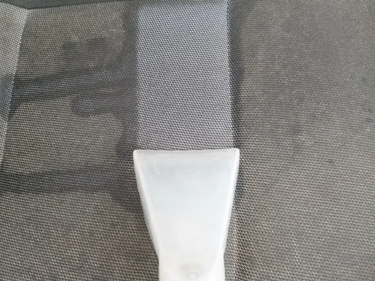 Zbliżenie na wyzcyszczoną część siedziska fotela tapicerowanego w aucie.