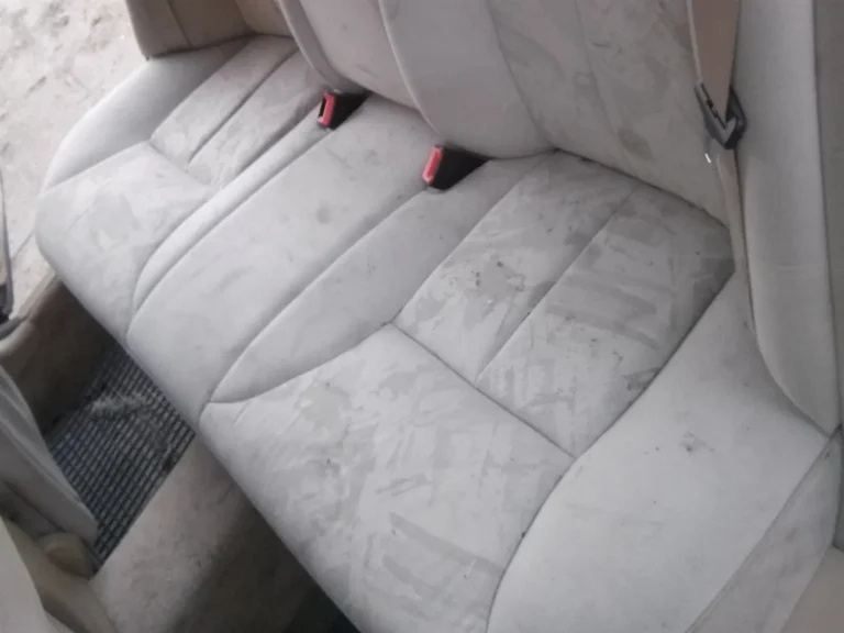 Tekstylna kanapa tapicerowana w samochodzie przed praniem. Widoczne plamy.