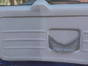 Do połowy wyczyszczone plastikowe wnętrze drzwi auta terenowego.