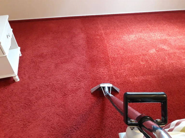 Czyszczenie czerwonej wykładziny z włosem.